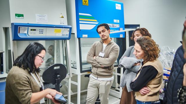 A group of people with diabetes talk to a researcher in a lab