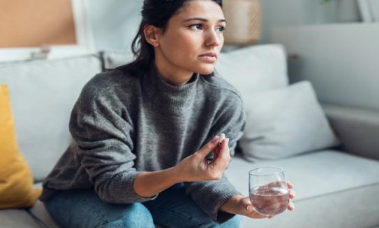 woman takes pill with water
